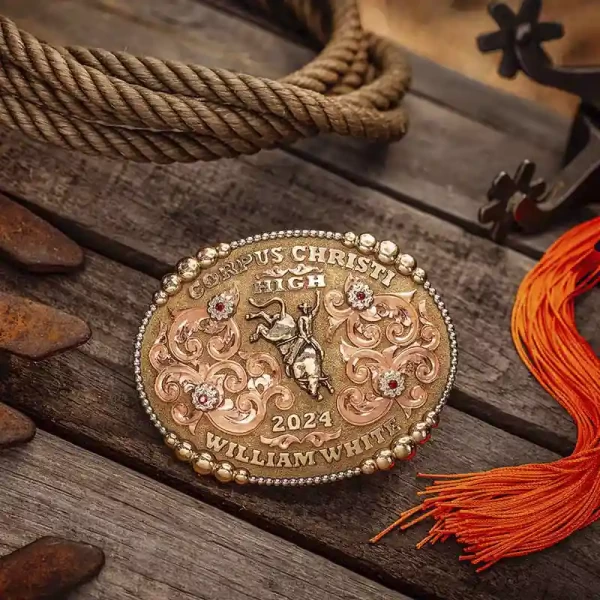 A custom rodeo belt buckle for Corpus Christi High School with personalized name featuring a golden bronze cowboy figure 
